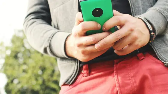 Elinde telefonla mesaj yazan bir kişi